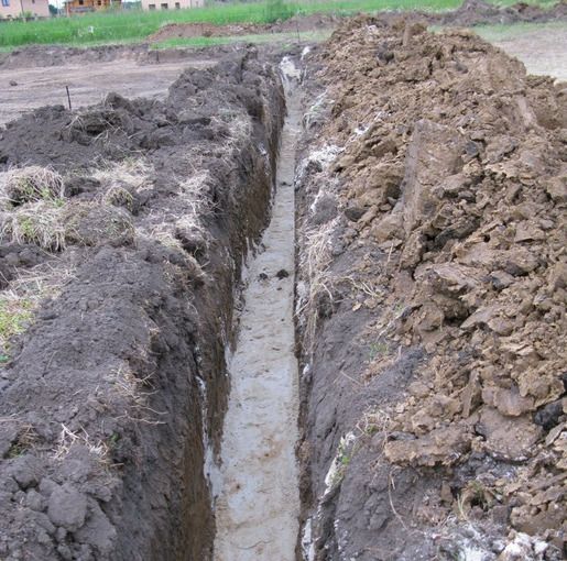 Дно траншеї засипають піском