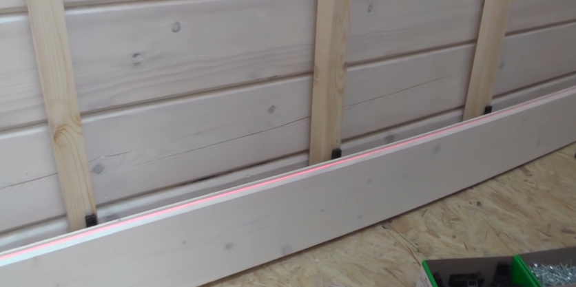 На фото показаний приклад використання лазерного рівня для установки панелей