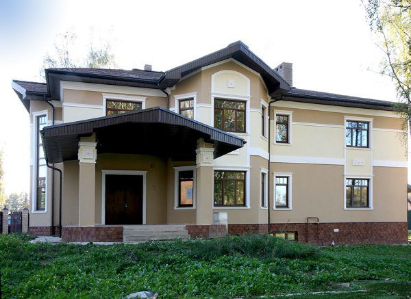 Оштукатурений фасад будинку в котеджному селищі