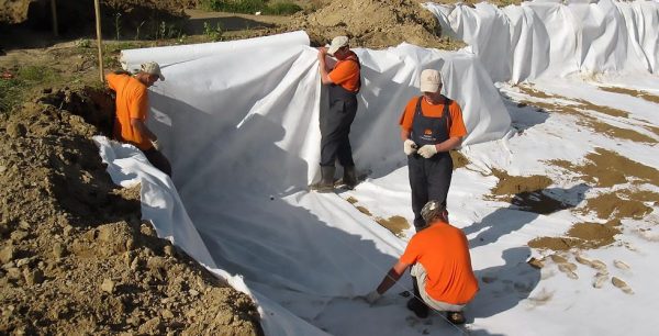 Поверх геотекстилю насипається невеликий шар піску